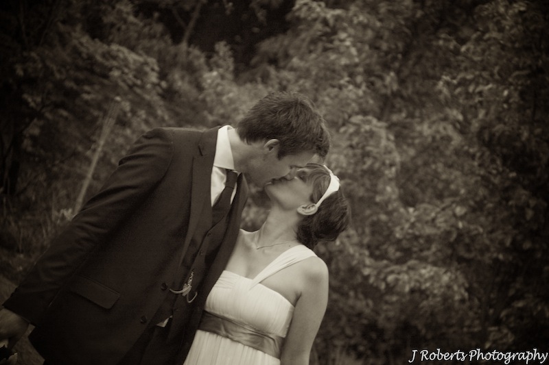Bride and groom kissing sepia - wedding photography